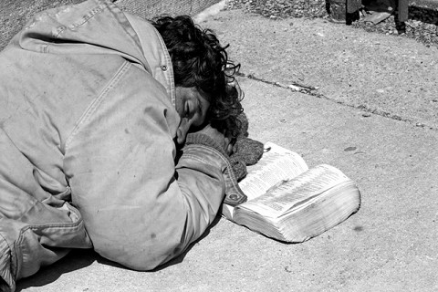 homeless man sleeping with his bible